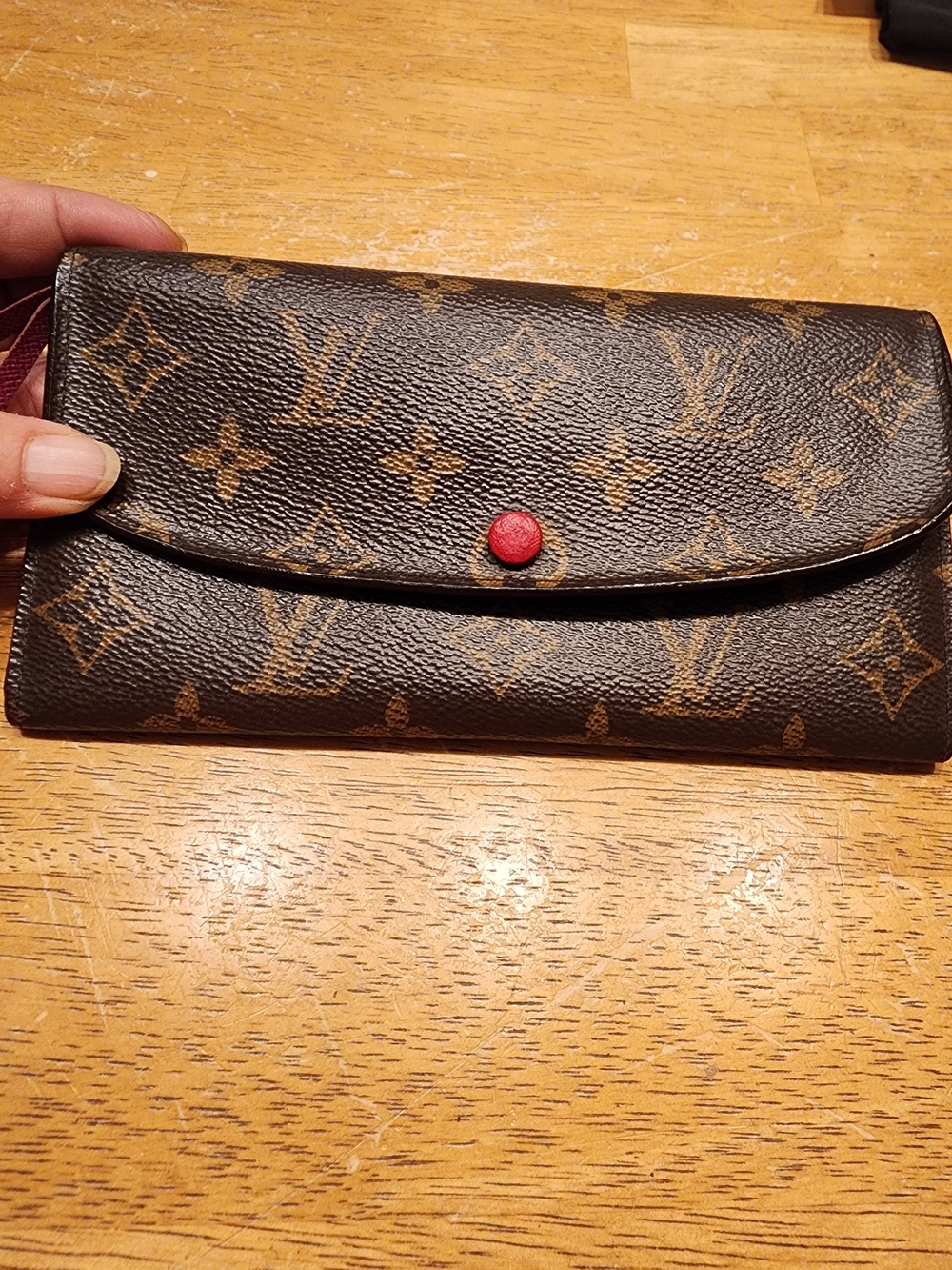 Louis Vuitton Monogram Emilie Wallet in the Rouge (red) colorway.